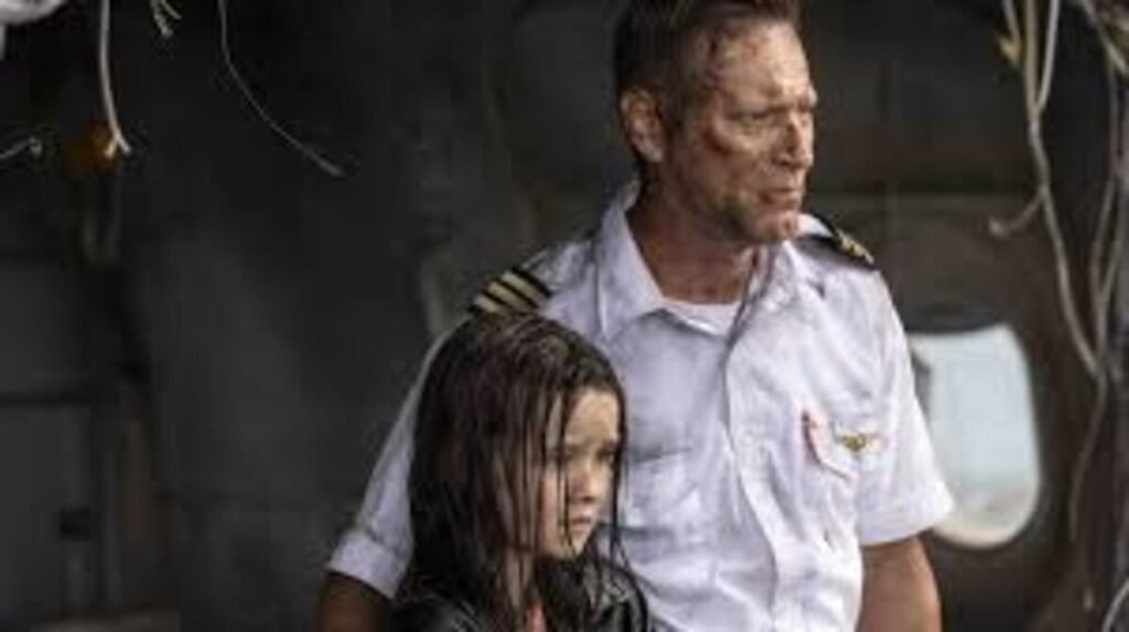 Cena dramática de sobrevivência em ambiente de destroços. À direita, um homem adulto com uniforme de piloto de avião, camisa branca com insígnias nos ombros, aparece com o rosto machucado, marcas de sangue e expressão exausta enquanto olha fixamente para o lado. À sua frente, protegida por seu braço, está uma menina com os cabelos longos e escuros completamente molhados, vestindo uma jaqueta preta e com um semblante abatido. O fundo está escuro e fora de foco, sugerindo o interior ou a proximidade da fuselagem danificada.