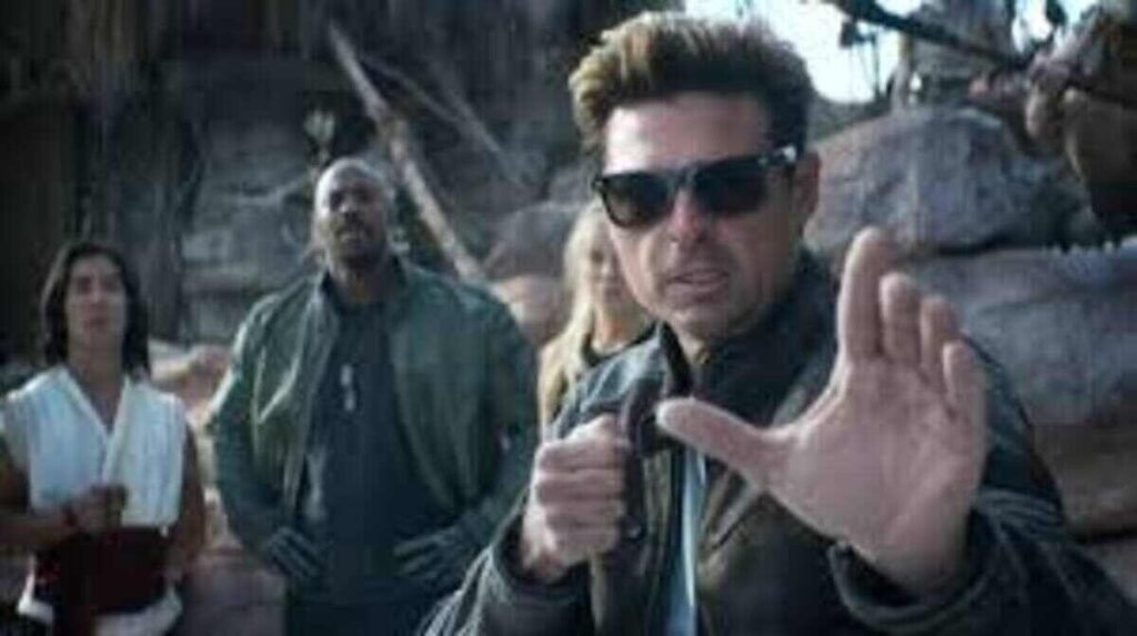 Johnny Cage e os defensores do Plano Terreno em cena de ação do filme Mortal Kombat dois. A imagem destaca o visual do personagem Johnny Cage e seus companheiros Liu Kang, Jax e Sonya Blade, ideal para ilustrar críticas, novidades e a cronologia da franquia no site.