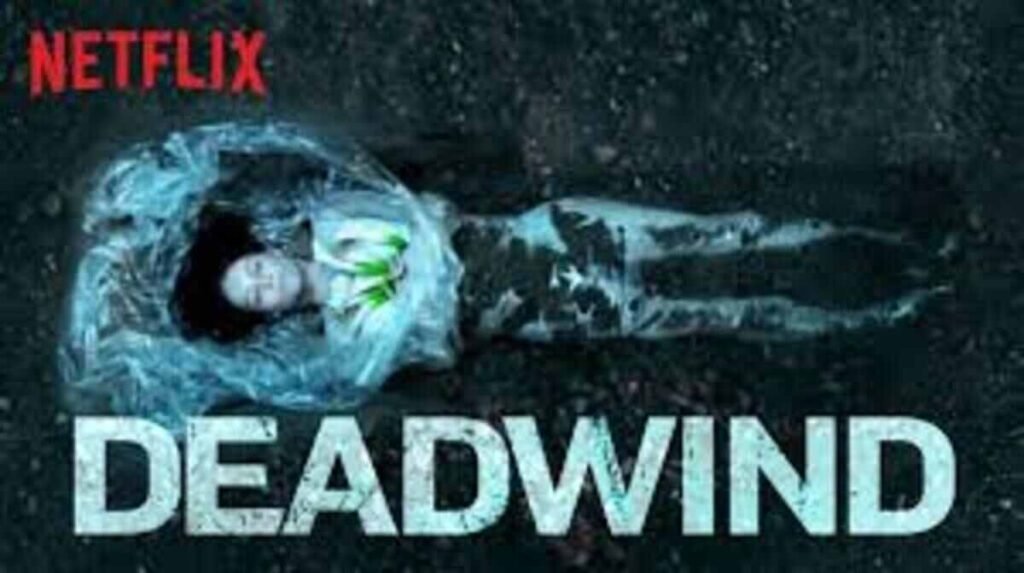 Pôster promocional da série de suspense Deadwind visto de uma perspectiva aérea vertical. No centro, o corpo de uma mulher loira está estendido e parcialmente enterrado na terra escura e úmida. A parte superior do seu corpo e a cabeça estão envoltas em um plástico transparente que se mistura com o solo. No canto superior esquerdo, o logotipo da Netflix aparece em destaque na cor vermelha. Na parte inferior, o título Deadwind está escrito em letras maiúsculas brancas grandes, com uma textura levemente desgastada e suja de terra.