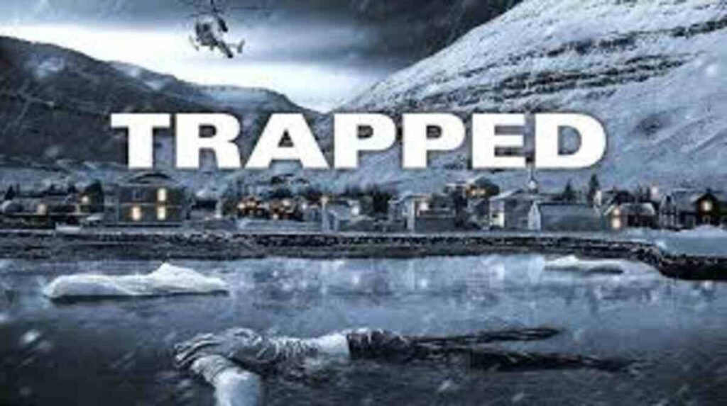 Pôster promocional da série de suspense Trapped. A imagem mostra uma paisagem gélida e isolada da Islândia, com montanhas cobertas de neve ao fundo e um vilarejo com pequenas casas iluminadas à beira de um rio congelado. No céu cinzento e tempestuoso, um helicóptero voa baixo. Em primeiro plano, boiando na água congelada em meio a blocos de gelo, aparece o corpo de uma vítima. No centro da imagem, o título Trapped está escrito em letras maiúsculas brancas e grossas.