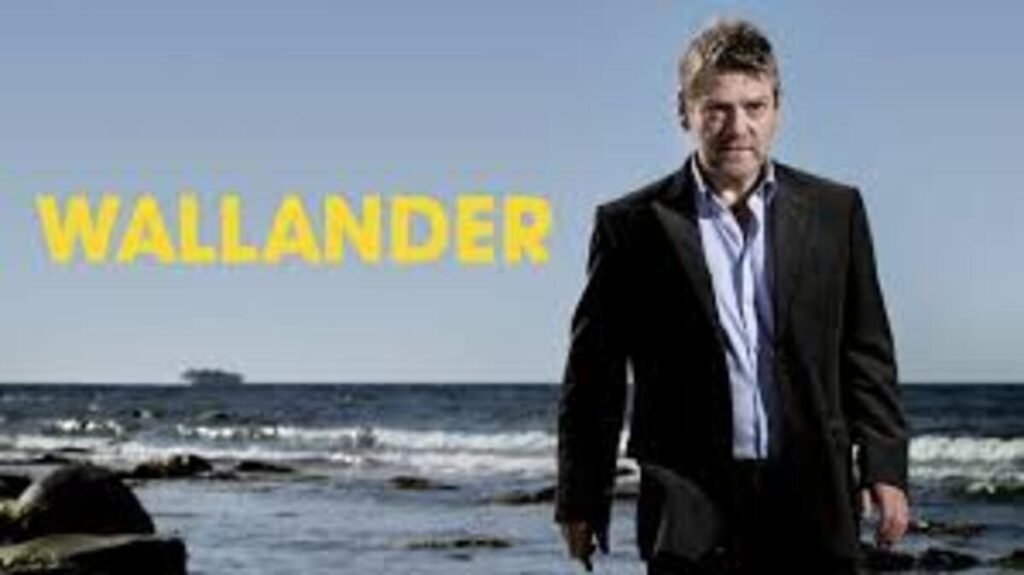 Pôster promocional da série policial Wallander. À direita, o protagonista interpretado por Kenneth Branagh caminha em direção ao espectador usando um terno escuro sobre uma camisa social clara levemente aberta no colarinho, exibindo uma expressão focada e séria. Ele está em uma praia de pedras, com o mar calmo ao fundo sob um céu azul e limpo. À esquerda, o título Wallander está escrito em letras maiúsculas amarelas com uma tipografia marcante.