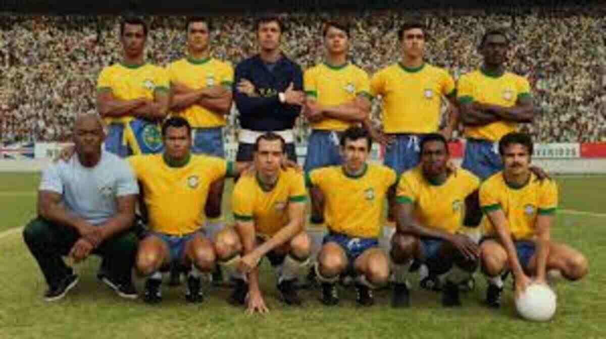 Foto histórica colorida da Seleção Brasileira de Futebol posando perfilada no gramado de um estádio lotado. O elenco está organizado em duas fileiras principais. Na fileira de trás, em pé, aparecem vários jogadores vestindo a icônica camisa amarela com gola verde e calções azuis, além do goleiro posicionado ao centro com uniforme escuro de mangas compridas e braços cruzados. Na fileira da frente, os atletas aparecem agachados no gramado vestindo o mesmo uniforme, com o jogador da extremidade direita apoiando as mãos sobre uma bola de futebol branca. À esquerda, um integrante da comissão técnica aparece agachado vestindo uma camisa clara de mangas curtas e calça escura. Ao fundo, a arquibancada do estádio está completamente tomada pelo público sob a luz do dia.