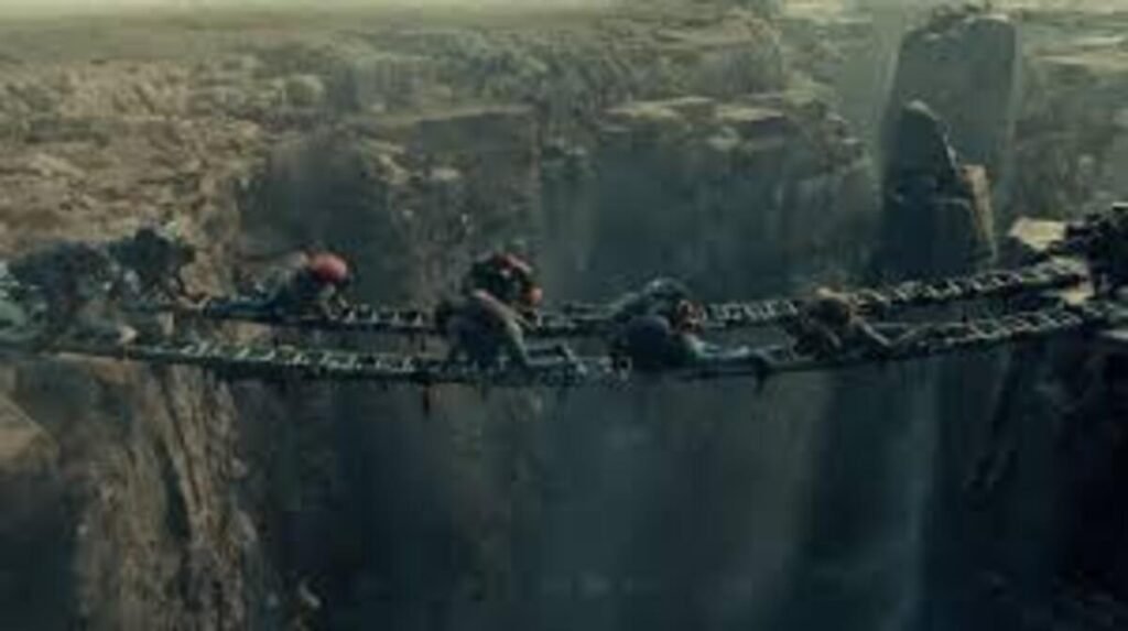 Sobreviventes realizando uma travessia perigosa rastejando sobre ponte suspensa em desfiladeiro na trama de ação do filme Destruição Final 2. A imagem promocional focada em cenas de grande escala, aventura extrema e sobrevivência pós-apocalíptica é ideal para ilustrar críticas de cinema, análises de momentos tensos e resumos do enredo no blog.