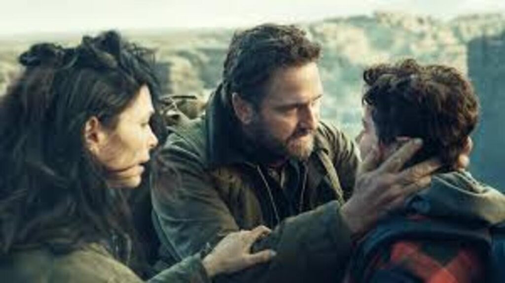 Pais confortando o filho em cena emocionante de sobrevivência familiar do filme Destruição Final 2. A imagem promocional destacando o drama humano e a união dos personagens principais diante do apocalipse é excelente para ilustrar críticas de cinema, análises de atuações e postagens de ficção científica no blog.