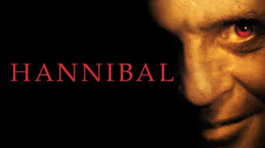 Pôster oficial com close-up sombrio destacando o olhar avermelhado de Anthony Hopkins na arte de divulgação do filme Hannibal. A imagem promocional focada no suspense psicológico e no terror do famoso personagem é perfeita para ilustrar críticas de cinema, ordens cronológicas de franquias e análises de vilões marcantes no blog.