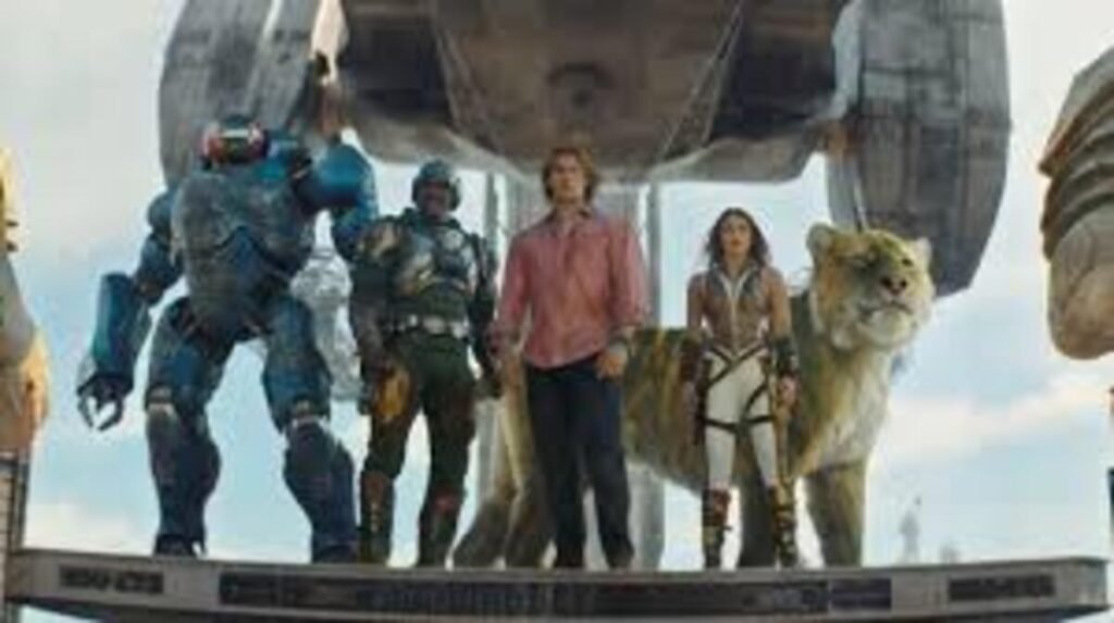 Cena oficial de ação e ficção científica do filme Mestres do Universo mostrando os defensores de Eternia reunidos em uma plataforma. A imagem promocional destacando o visual moderno dos guerreiros, robôs e criaturas fantásticas é ideal para ilustrar críticas de cinema, análises de efeitos visuais e posts sobre adaptações de ficção científica e fantasia no site.
