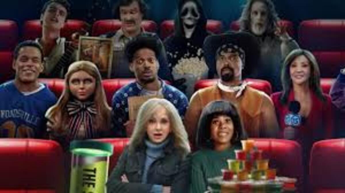 Pôster promocional ilustrado em plano médio de uma sala de cinema repleta de personagens icônicos da cultura pop e do terror sentados em poltronas vermelhas. Na fileira da frente, da esquerda para a direita, uma mulher loira com maquiagem marcante e figurino brilhante posa ao lado de um balde verde escrito Scary Movie; ao centro, uma mulher de cabelos loiros e ondulados cruza os braços com expressão séria; ao seu lado, outra mulher sorri diante de um grande combo de pipoca decorado; e na ponta direita, um homem assustado segura um cartaz branco escrito The Mask is Alive. Atrás deles, destacam-se a boneca M3GAN com seu laço clássico, um jovem de cabelo afro, o vilão Ghostface segurando um balde de pipoca, uma criatura zumbi e várias outras figuras parodiadas olhando fixamente em direção ao espectador.