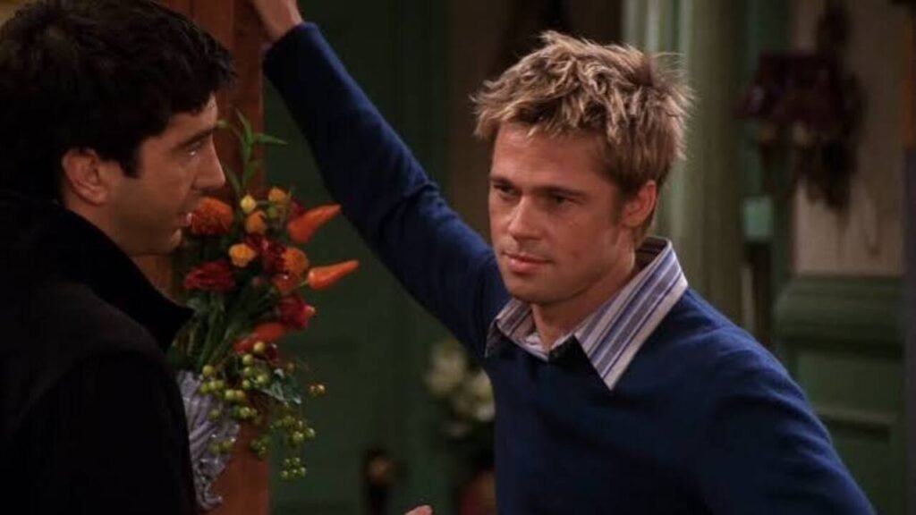 Famosos na TV: Participações especiais em séries que você pode ter deixado passar 2 Brad Pitt e David Schwimmer em cena de grande destaque durante um episódio especial de comédia na televisão. A imagem capturando a famosa participação especial de Hollywood é perfeita para ilustrar listas de curiosidades de bastidores, momentos marcantes da cultura pop e análises de episódios clássicos no site.